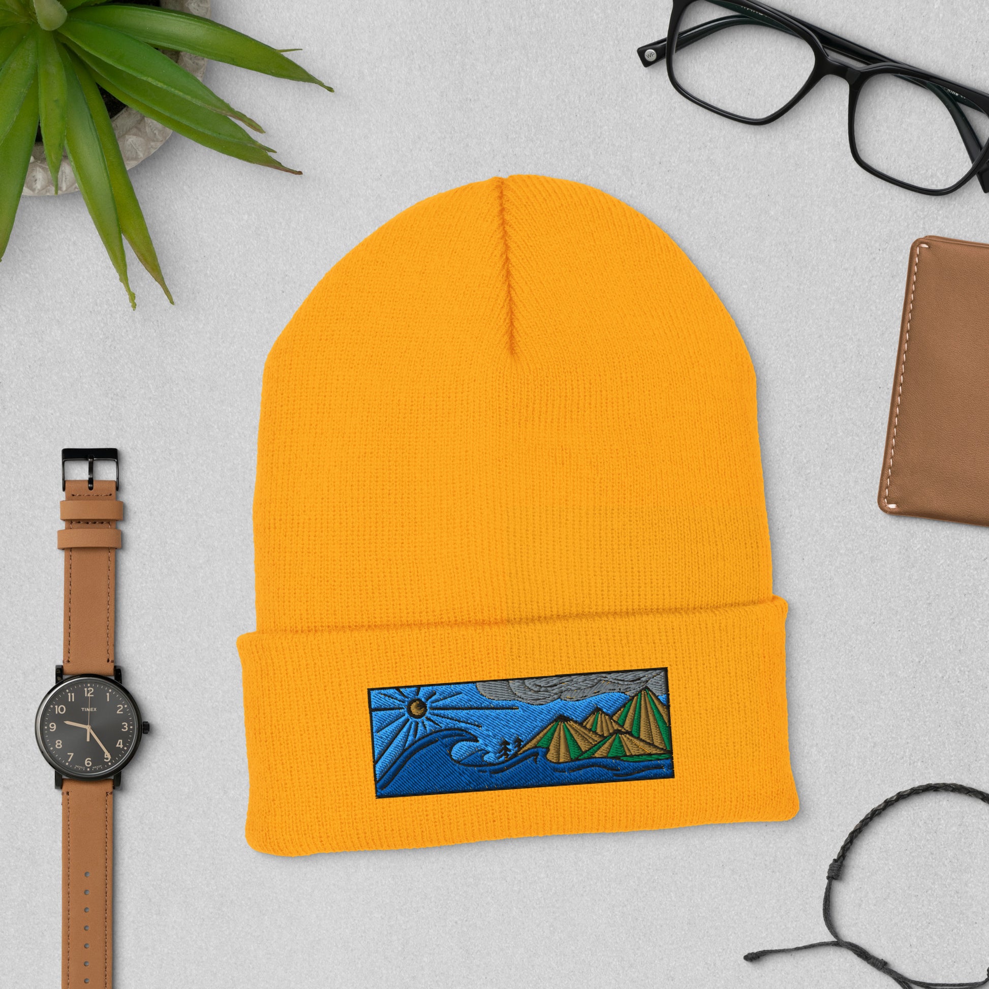 Product mockupcuffed beanie, colored embroidery of seascape and mountains, gold